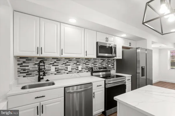 a kitchen with a sink a stove a refrigerator and cabinets