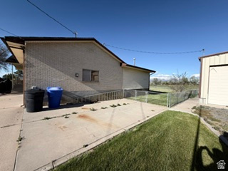 588 North 4500 West West Point, UT 84015 - Photo 49 of 61 Brick exterior with a sheltered entry, concrete patio, and fenced grass area