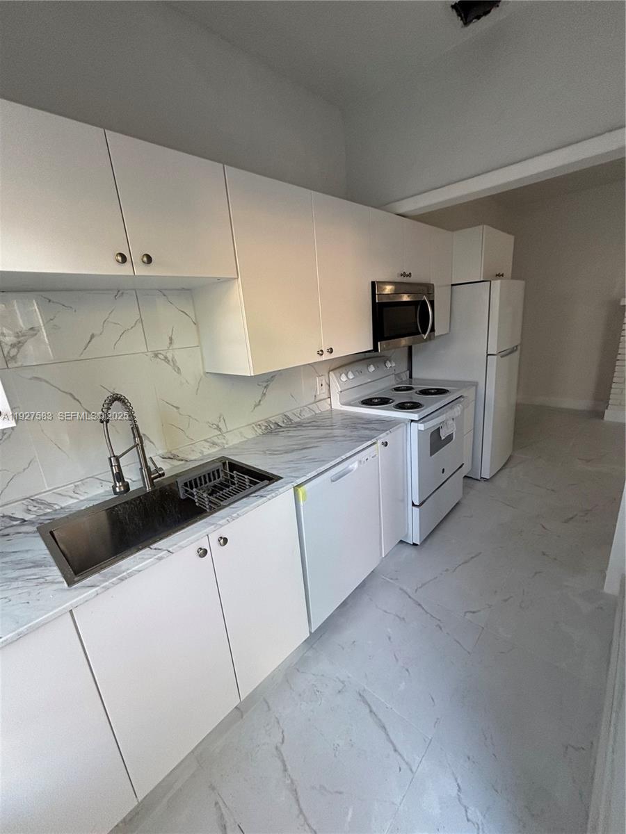 568 Southwest 3rd Street, Unit LEFT 566 Miami, FL 33130 - Photo 4 of 17 a kitchen with stainless steel appliances granite countertop a sink and a stove