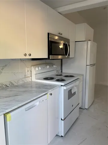 a kitchen with stainless steel appliances white cabinets and a sink