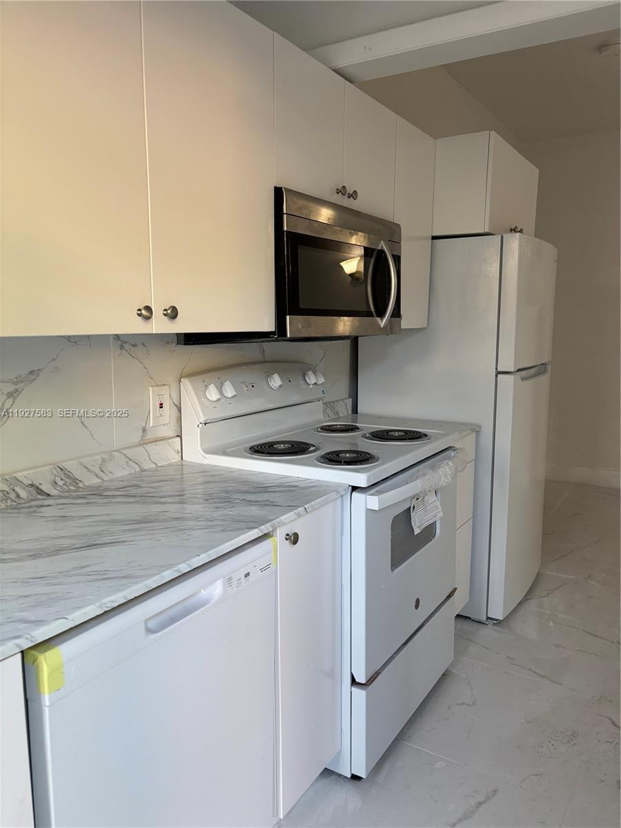 568 Southwest 3rd Street, Unit LEFT 566 Miami, FL 33130 - Photo 5 of 17 a kitchen with stainless steel appliances white cabinets and a sink