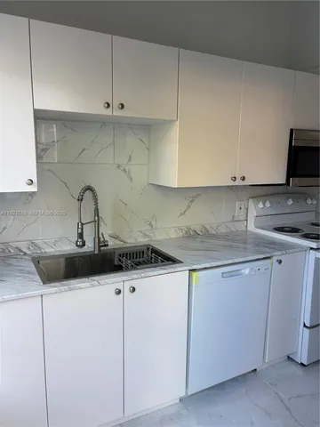 a kitchen with cabinets appliances and a sink