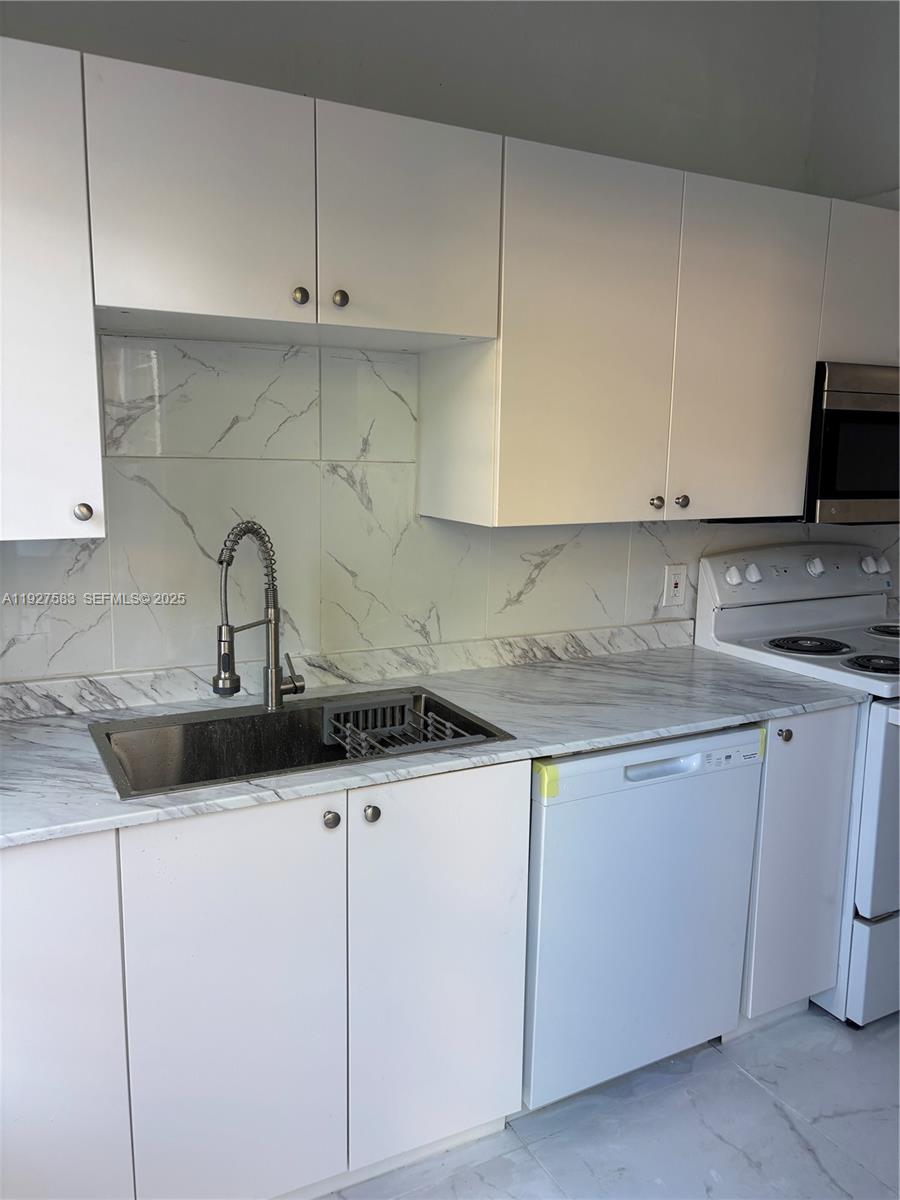 568 Southwest 3rd Street, Unit LEFT 566 Miami, FL 33130 - Photo 6 of 17 a kitchen with cabinets appliances and a sink