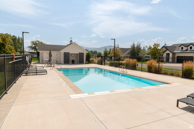 108 West Monte Rosa Lane Midway, UT 84049 - Photo 48 of 48 Outdoor swimming pool with integrated steps, surrounded by a concrete deck and black metal fencing
