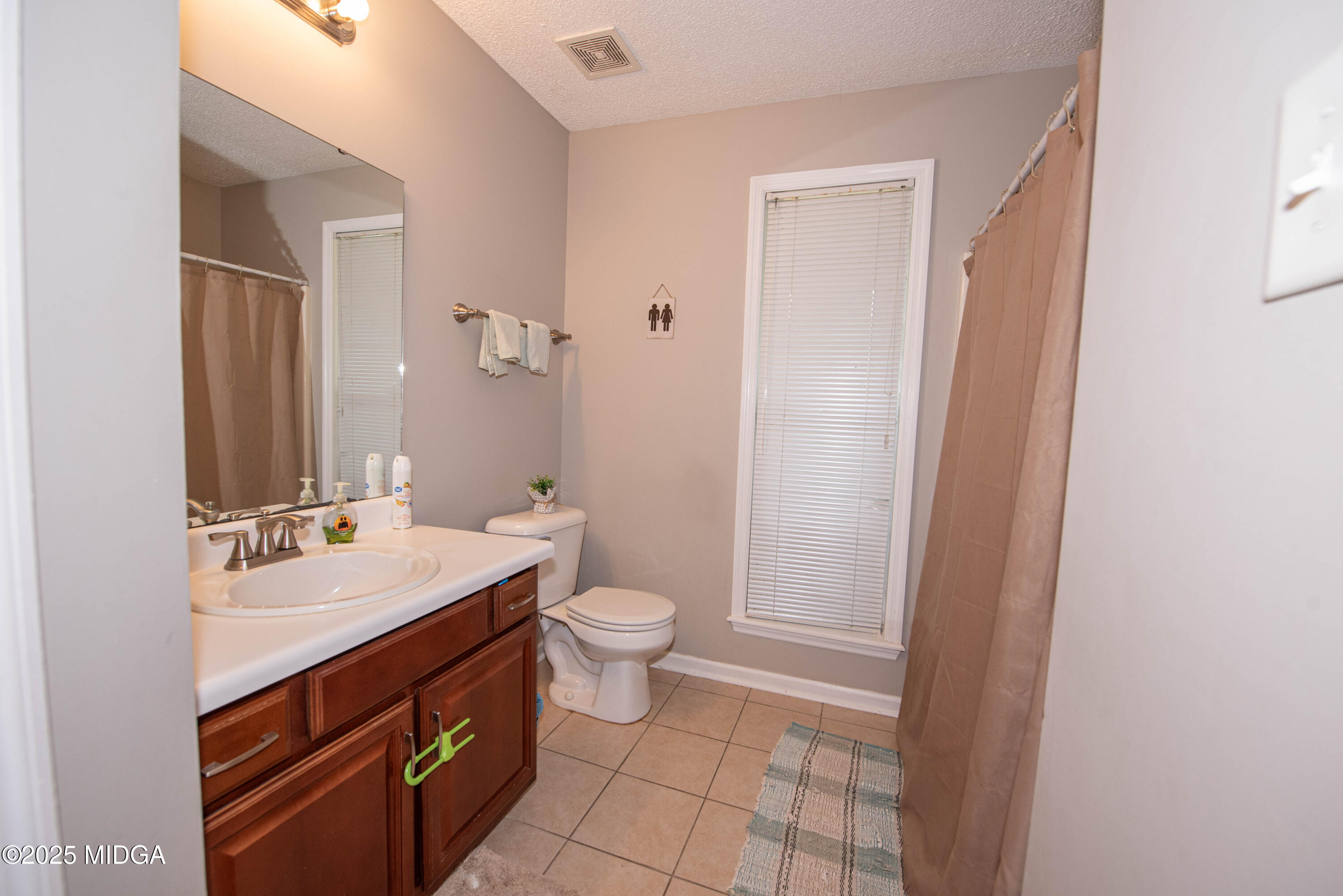 111 Oak Ridge Drive Warner Robins, GA 31093 - Photo 13 of 25 a bathroom with a sink a toilet a shower and a mirror