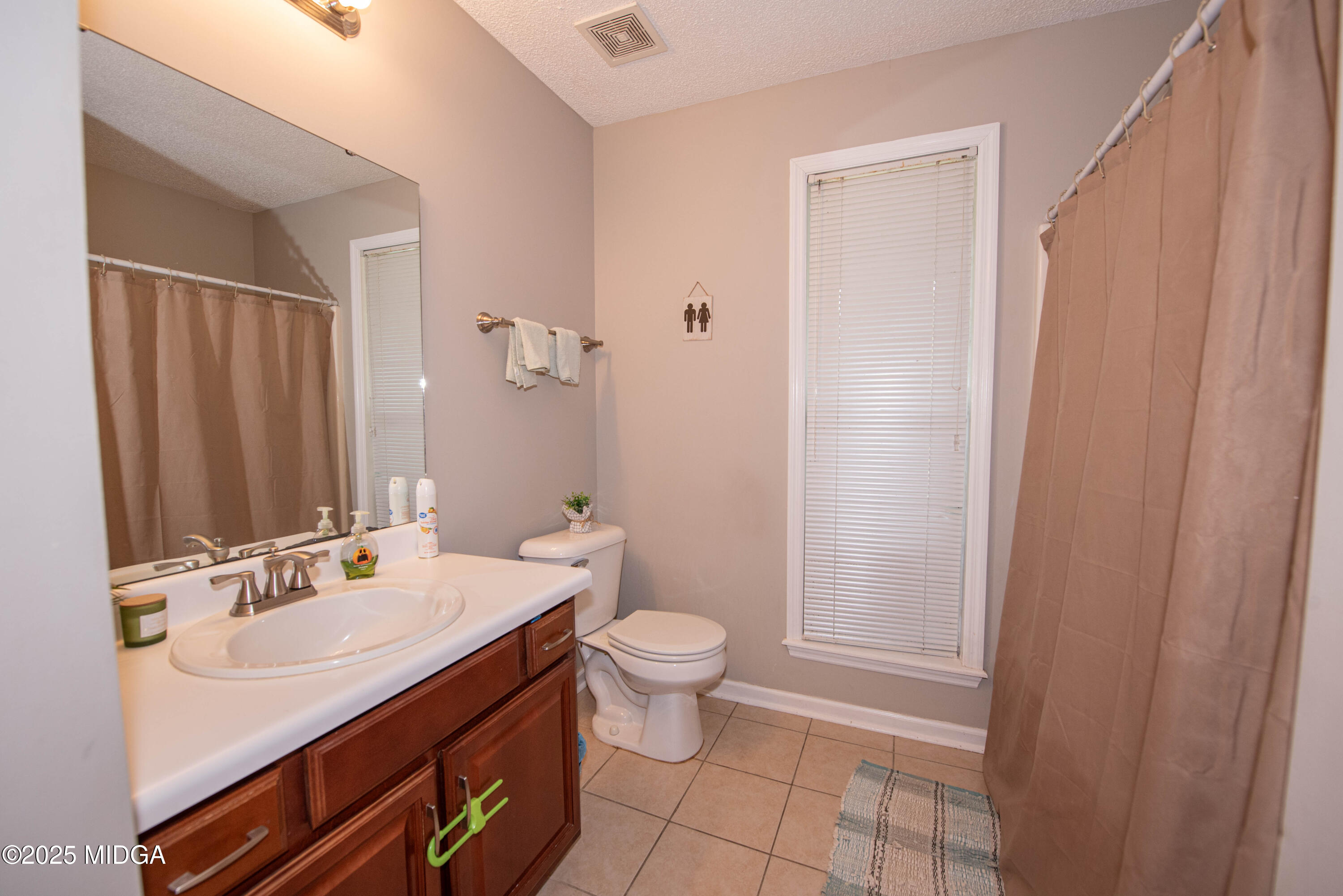 111 Oak Ridge Drive Warner Robins, GA 31093 - Photo 14 of 25 a bathroom with a sink a toilet a shower and a mirror