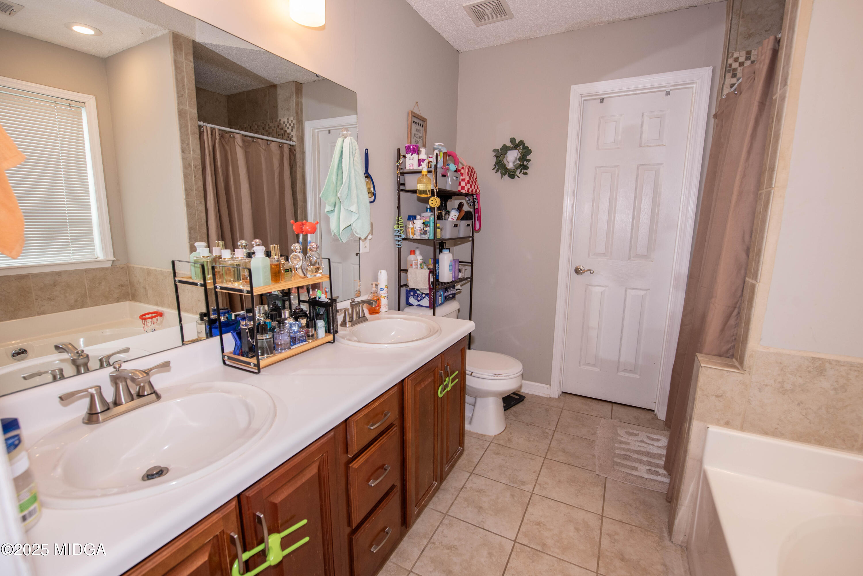 111 Oak Ridge Drive Warner Robins, GA 31093 - Photo 18 of 25 a bathroom with double vanity sink a mirror and a bathtub