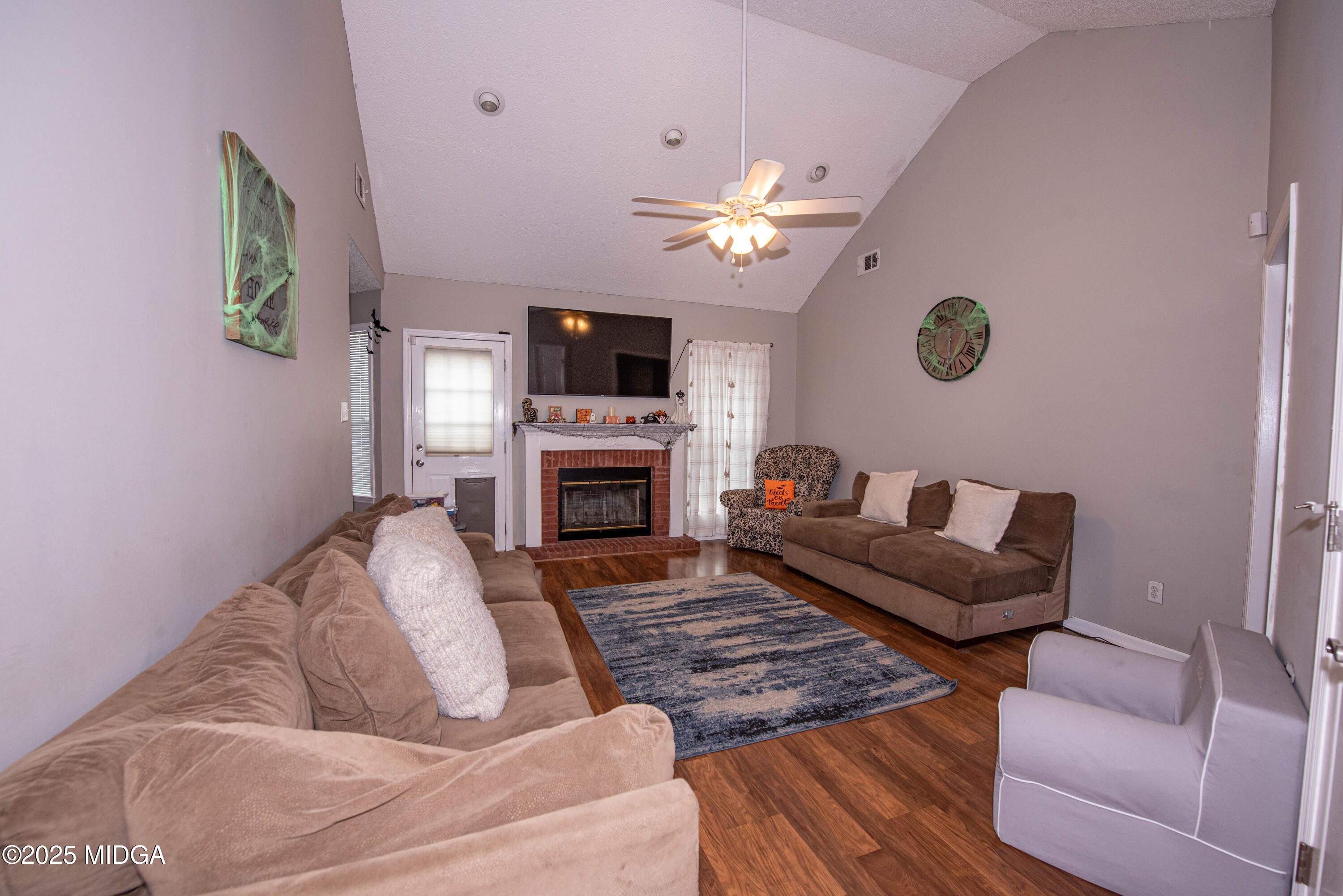 111 Oak Ridge Drive Warner Robins, GA 31093 - Photo 4 of 25 a living room with furniture a fireplace and a flat screen tv