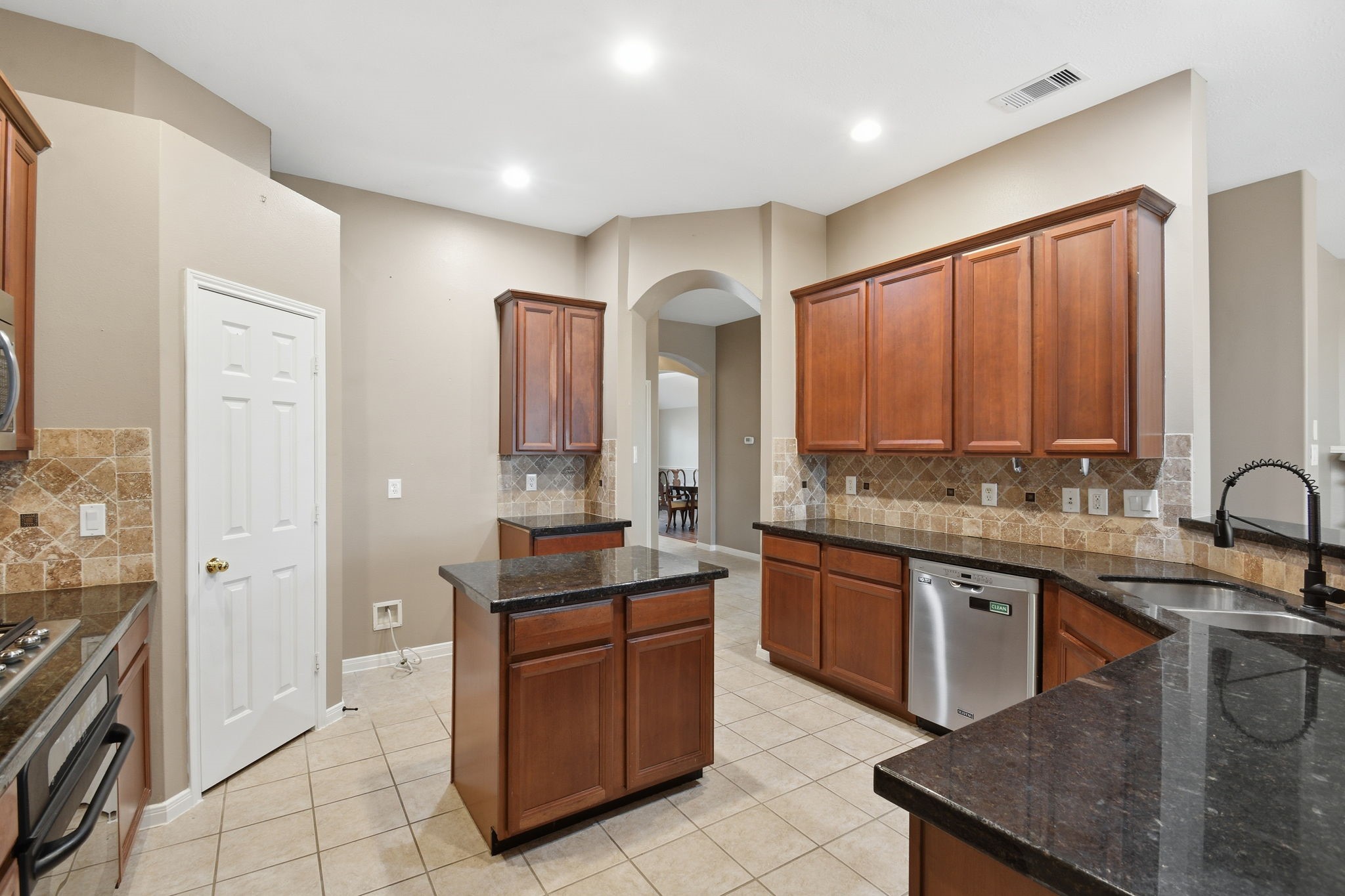 18915 Rustling Ridge Drive Tomball, TX 77377 - Photo 11 of 27 a large kitchen with granite countertop a sink and cabinets