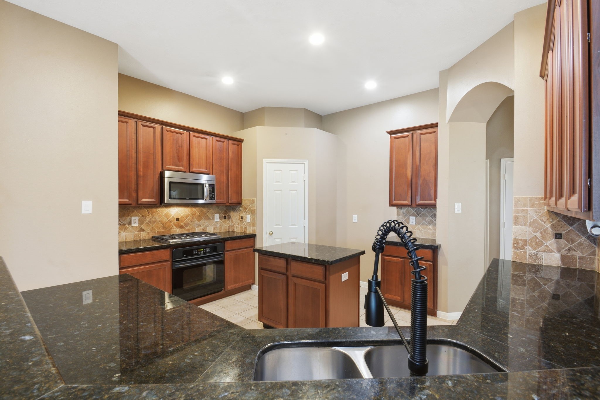 18915 Rustling Ridge Drive Tomball, TX 77377 - Photo 12 of 27 a kitchen with stainless steel appliances granite countertop a stove top oven a sink a dining table and chairs with wooden floor