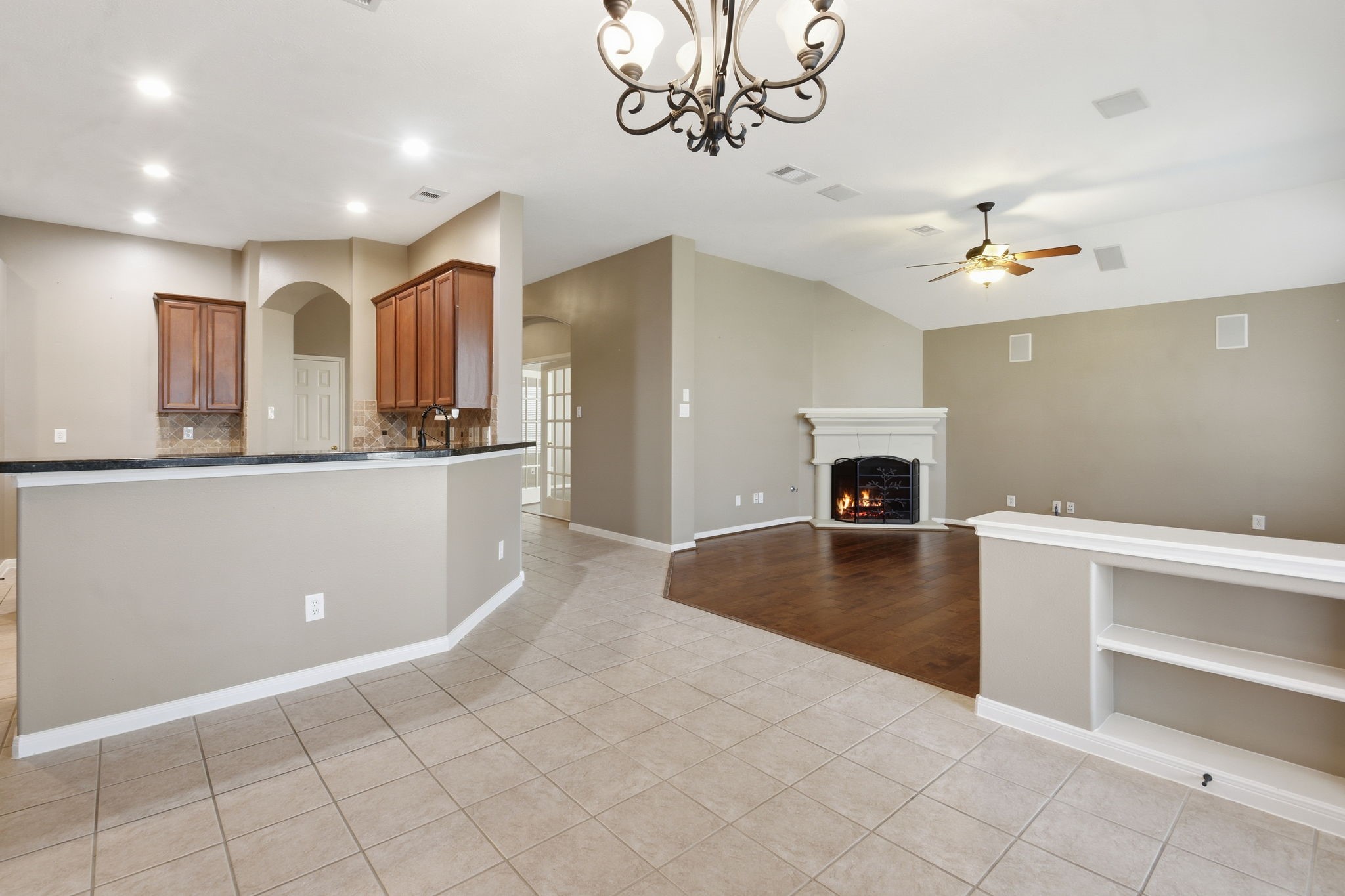 18915 Rustling Ridge Drive Tomball, TX 77377 - Photo 13 of 27 a view of a kitchen with a sink a fireplace a chandelier and wooden floor