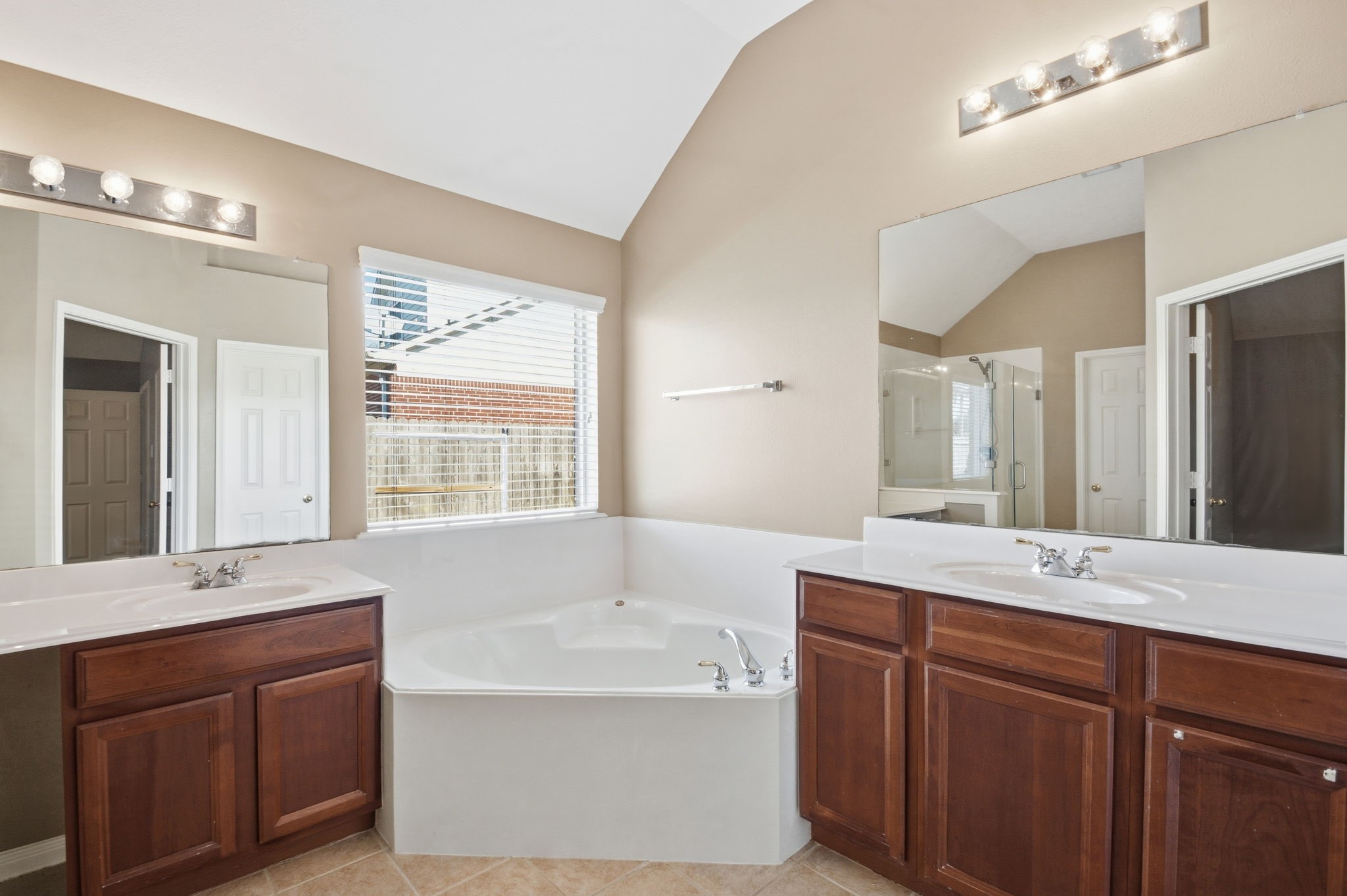 18915 Rustling Ridge Drive Tomball, TX 77377 - Photo 18 of 27 a bathroom with a tub double vanity sink and mirror