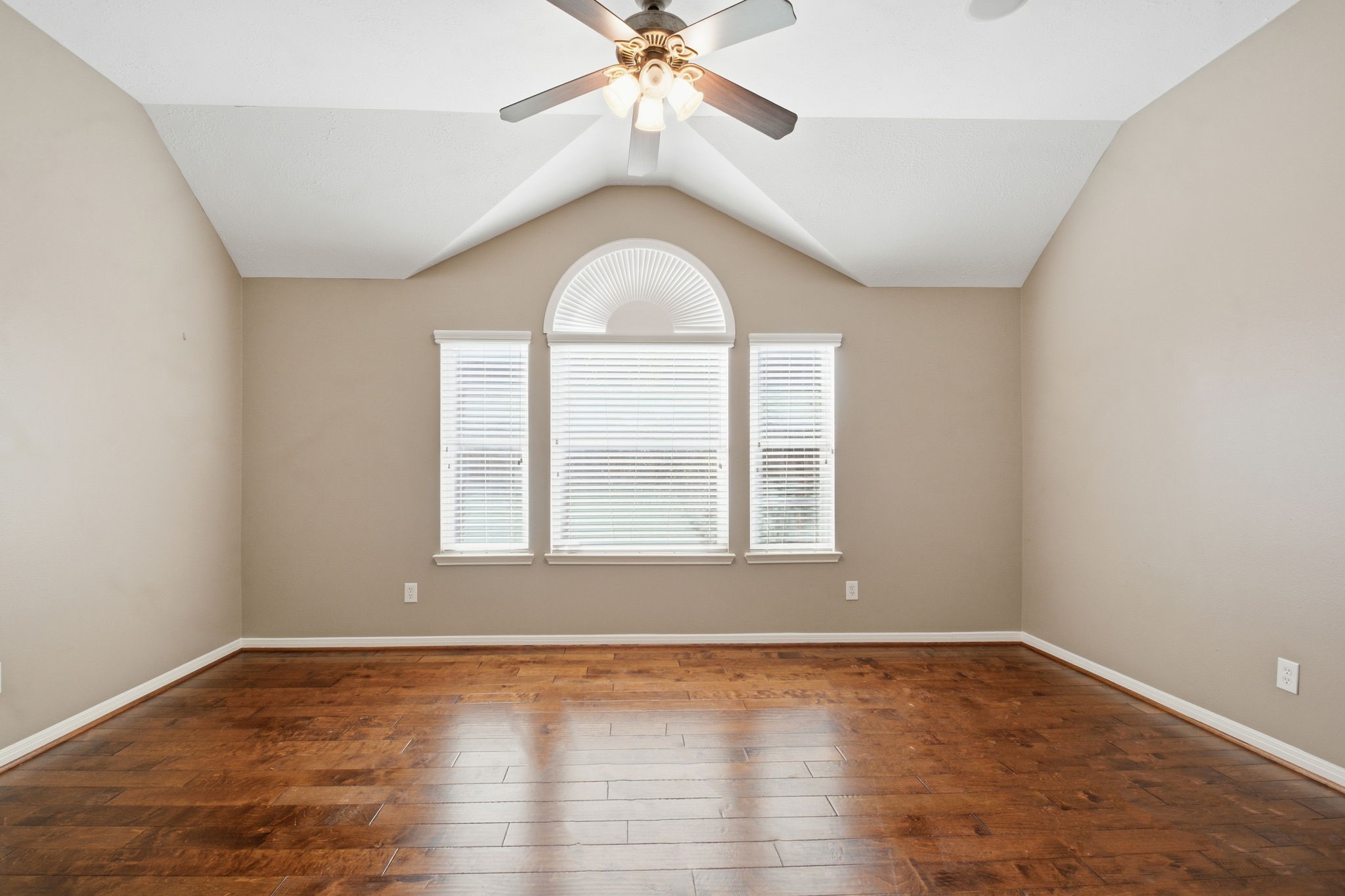 18915 Rustling Ridge Drive Tomball, TX 77377 - Photo 6 of 27 an empty room with wooden floor a chandelier fan and windows