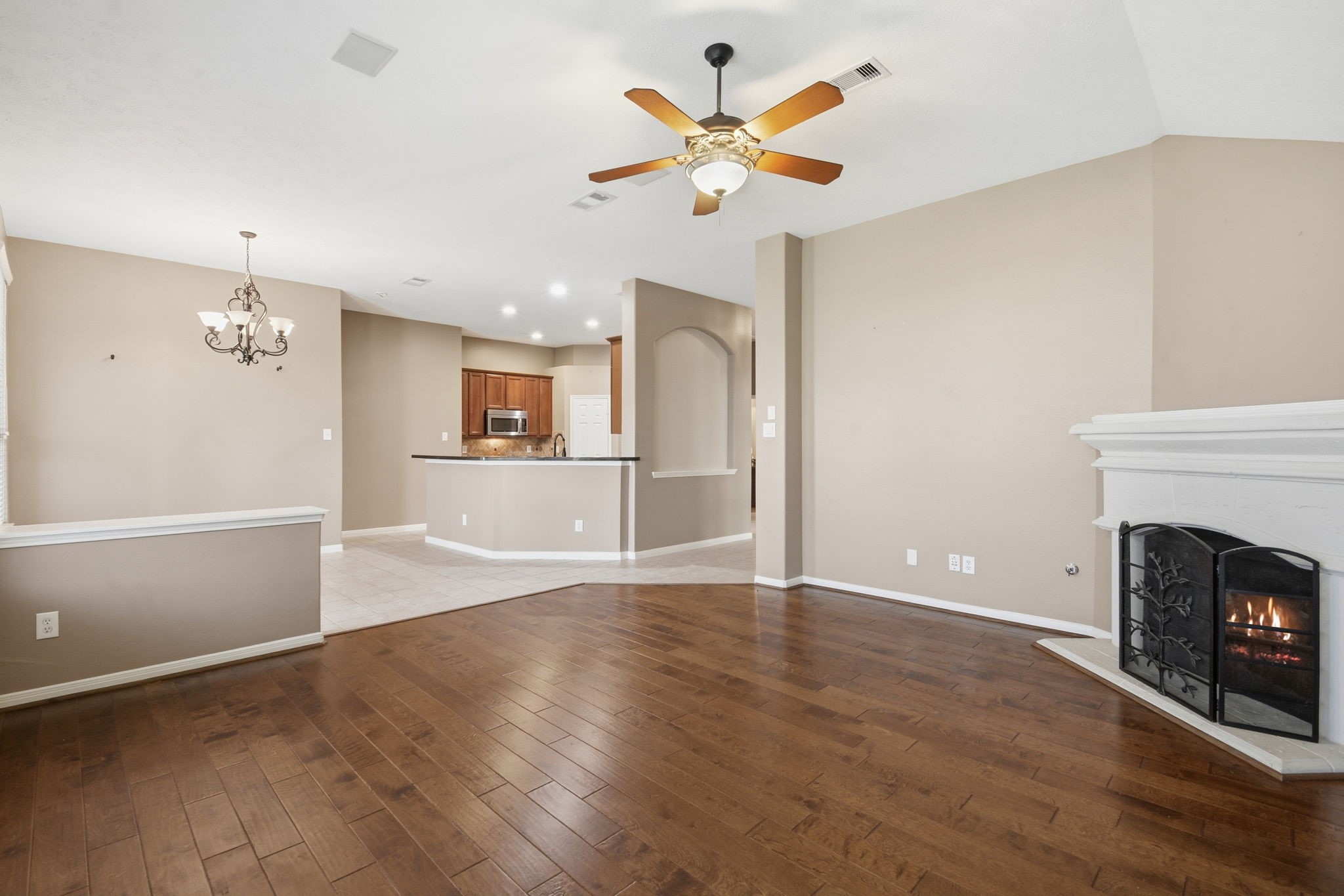 18915 Rustling Ridge Drive Tomball, TX 77377 - Photo 9 of 27 an empty room with wooden floor a fireplace and a window