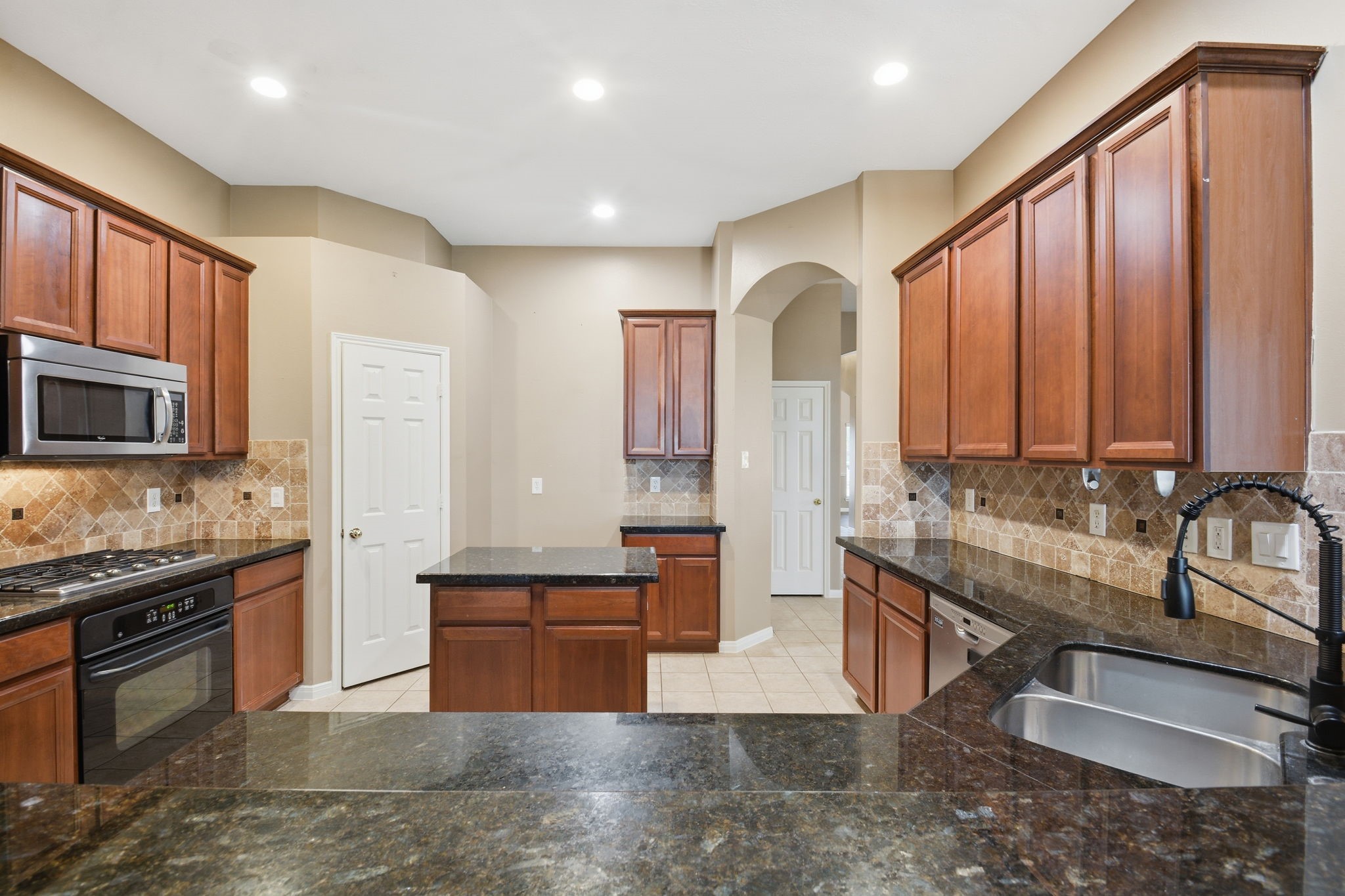 18915 Rustling Ridge Drive Tomball, TX 77377 - Photo 10 of 27 a kitchen with stainless steel appliances granite countertop a sink stove and cabinets