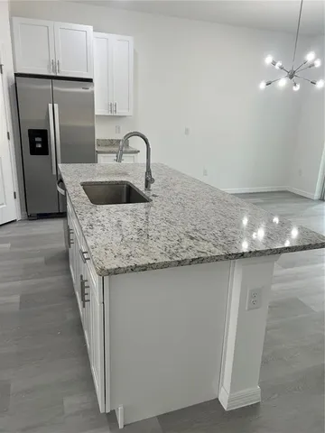 a kitchen with kitchen island a sink stainless steel appliances and cabinets