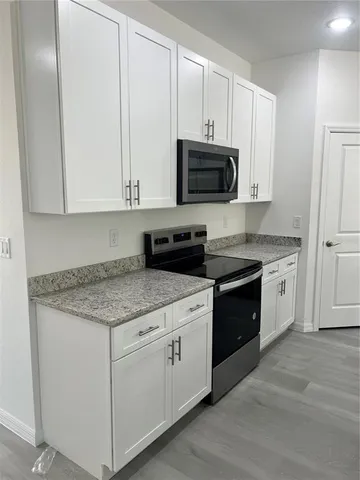 a kitchen with white cabinets and white appliances