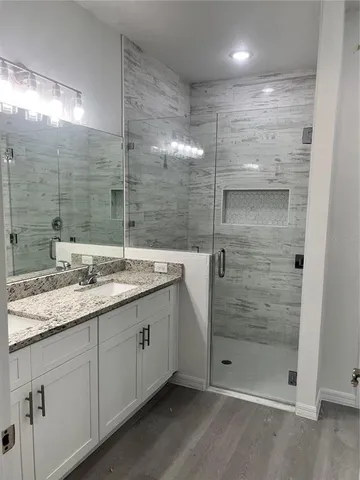 a bathroom with a shower sink and mirror