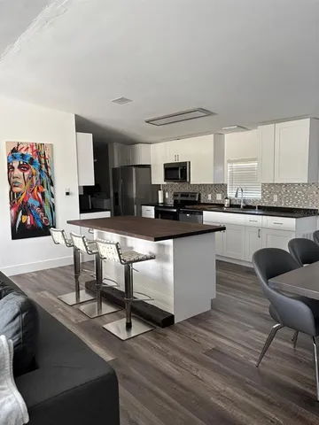 a kitchen with stainless steel appliances granite countertop a stove a sink and a refrigerator