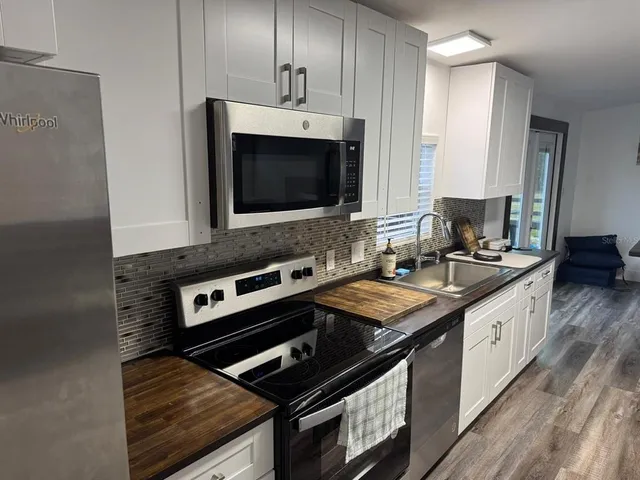 a kitchen with granite countertop white cabinets and white appliances