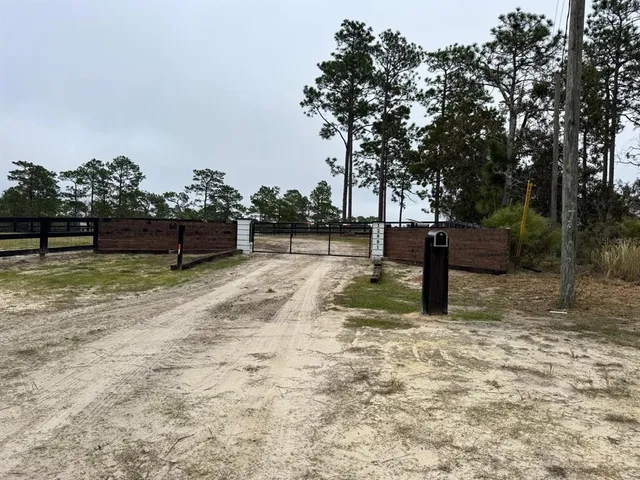 a view of a yard with wooden fence