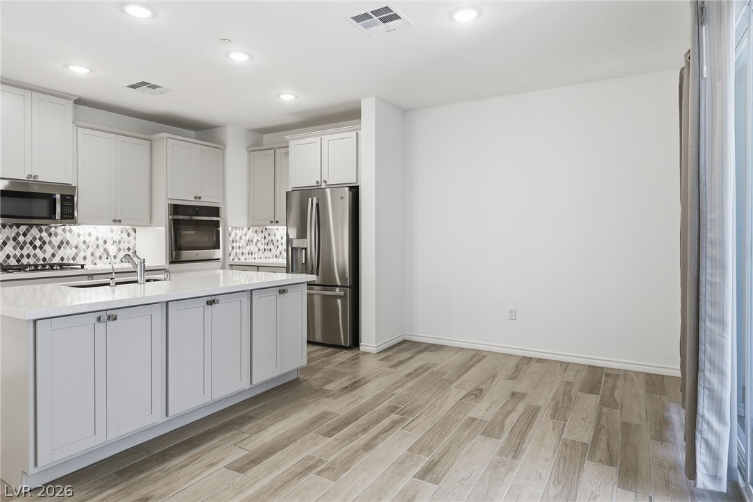 2555 Hampton Road, Unit 2208 Henderson, NV 89052 - Photo 13 of 45 Kitchen with s/s appliances, quartz counters and island, backsplash, showing dining area.