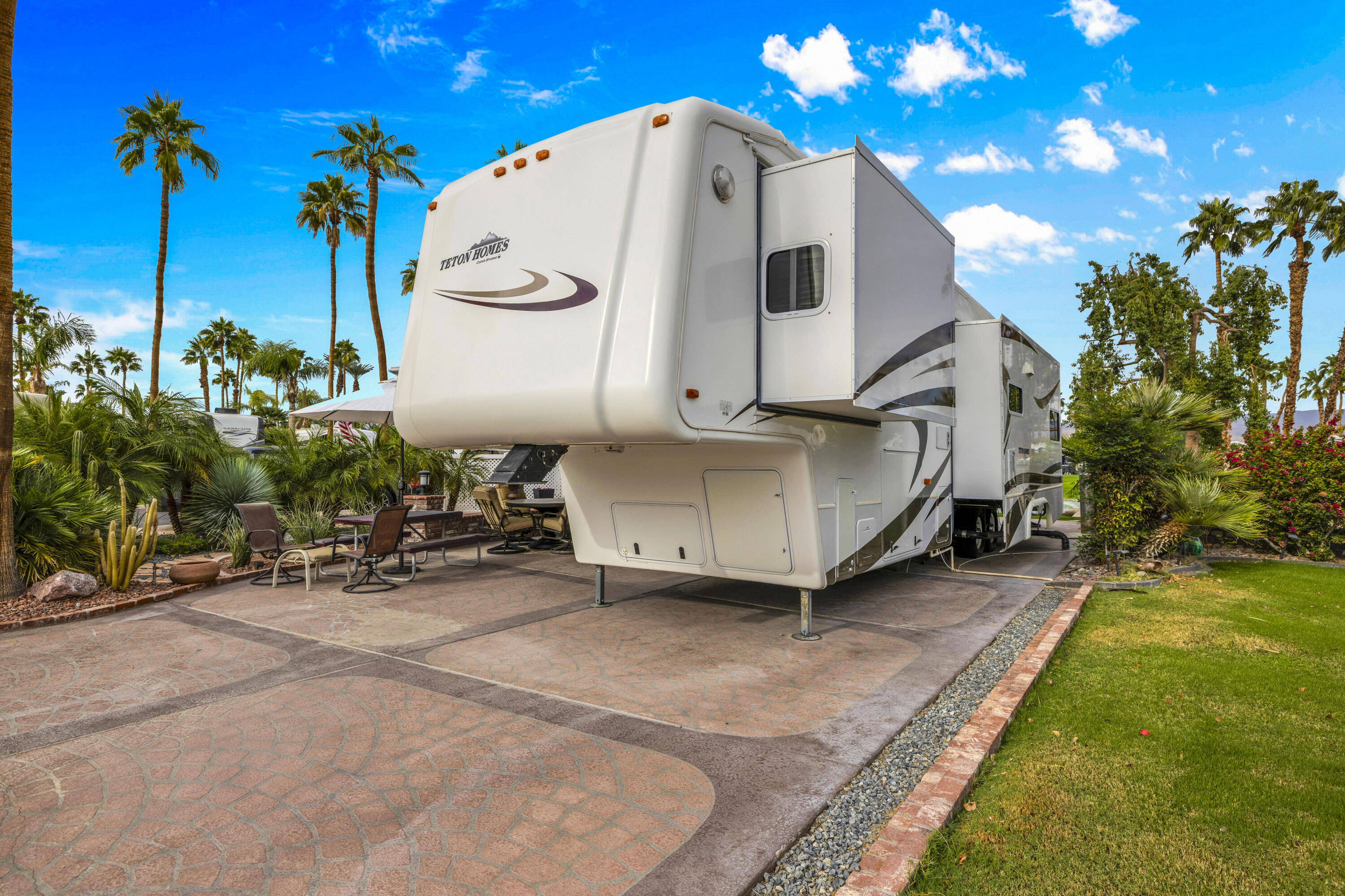 69411 Ramon Road, Unit 1203 Cathedral City, CA 92234 - Photo 21 of 74 a view of a white house with a yard and sitting area