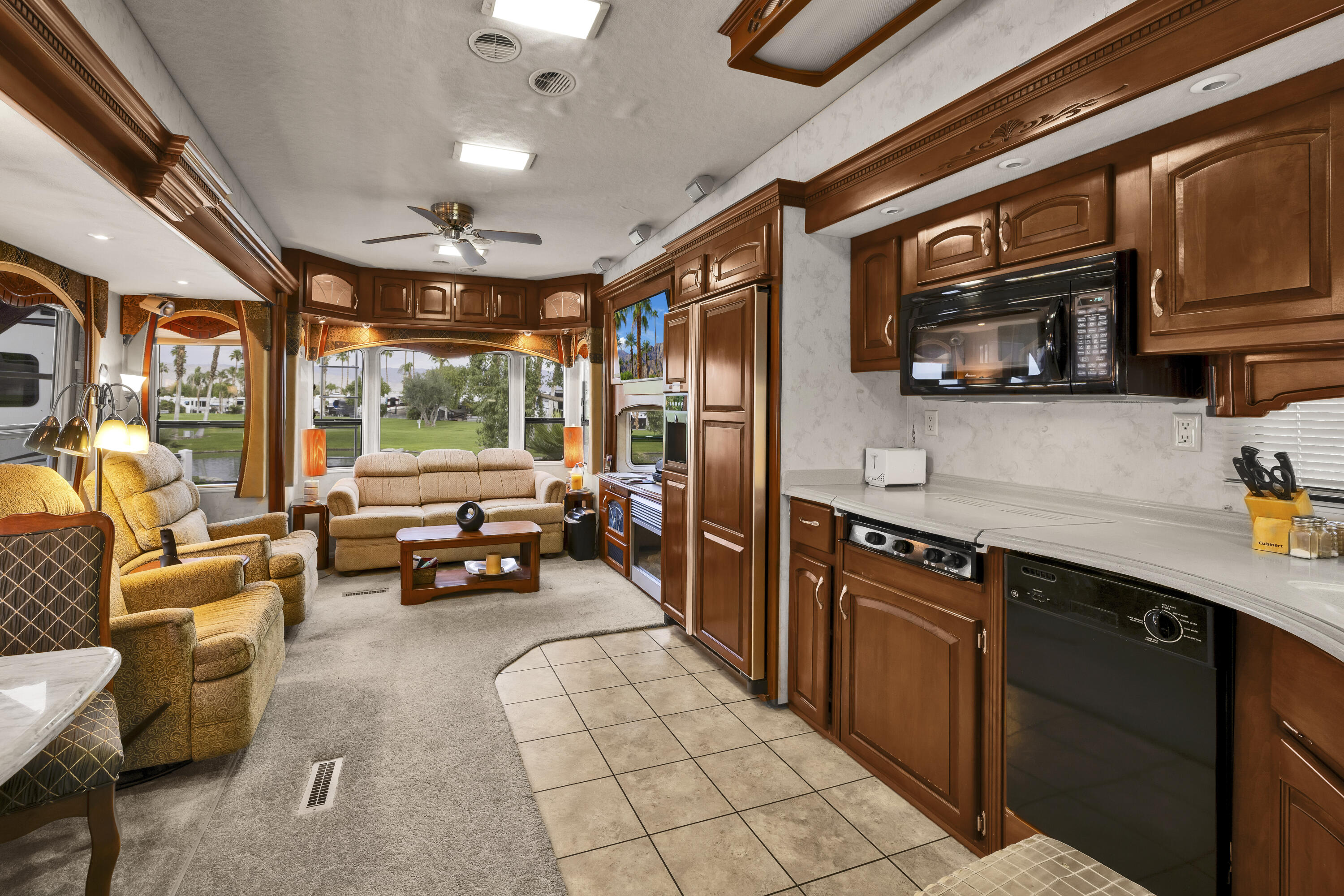 69411 Ramon Road, Unit 1203 Cathedral City, CA 92234 - Photo 31 of 74 a kitchen with stainless steel appliances granite countertop a barbecue grill and couches next to a large window