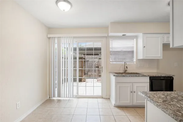 a kitchen with granite countertop a sink stove and cabinets