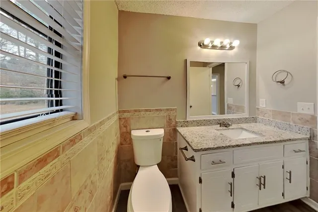 a bathroom with a granite countertop sink toilet and shower