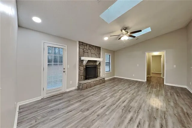 a view of empty room with wooden floor and fireplace