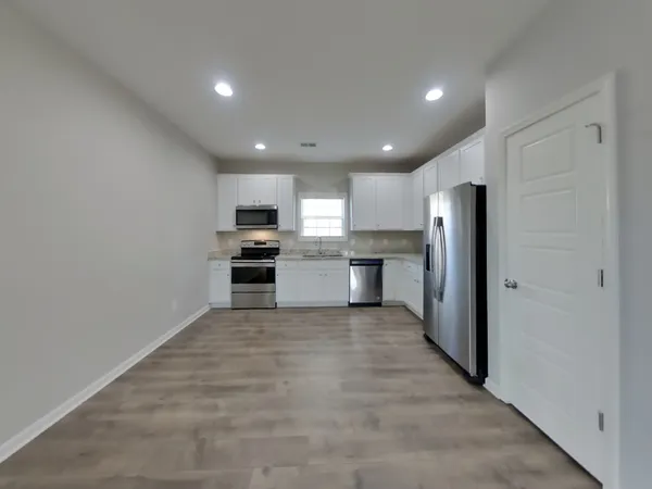 a view of kitchen with refrigerator sink microwave and cabinets