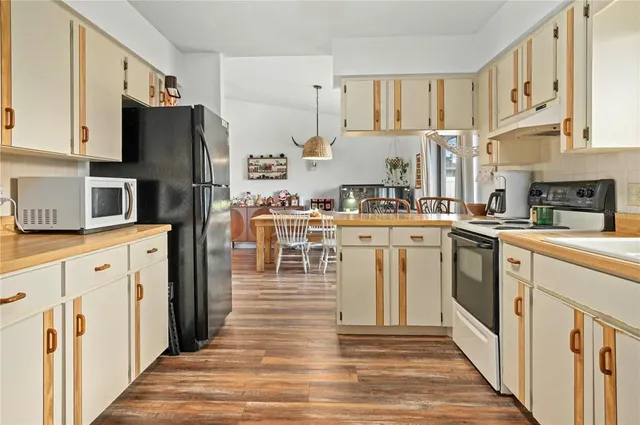 a kitchen with granite countertop a refrigerator and a sink