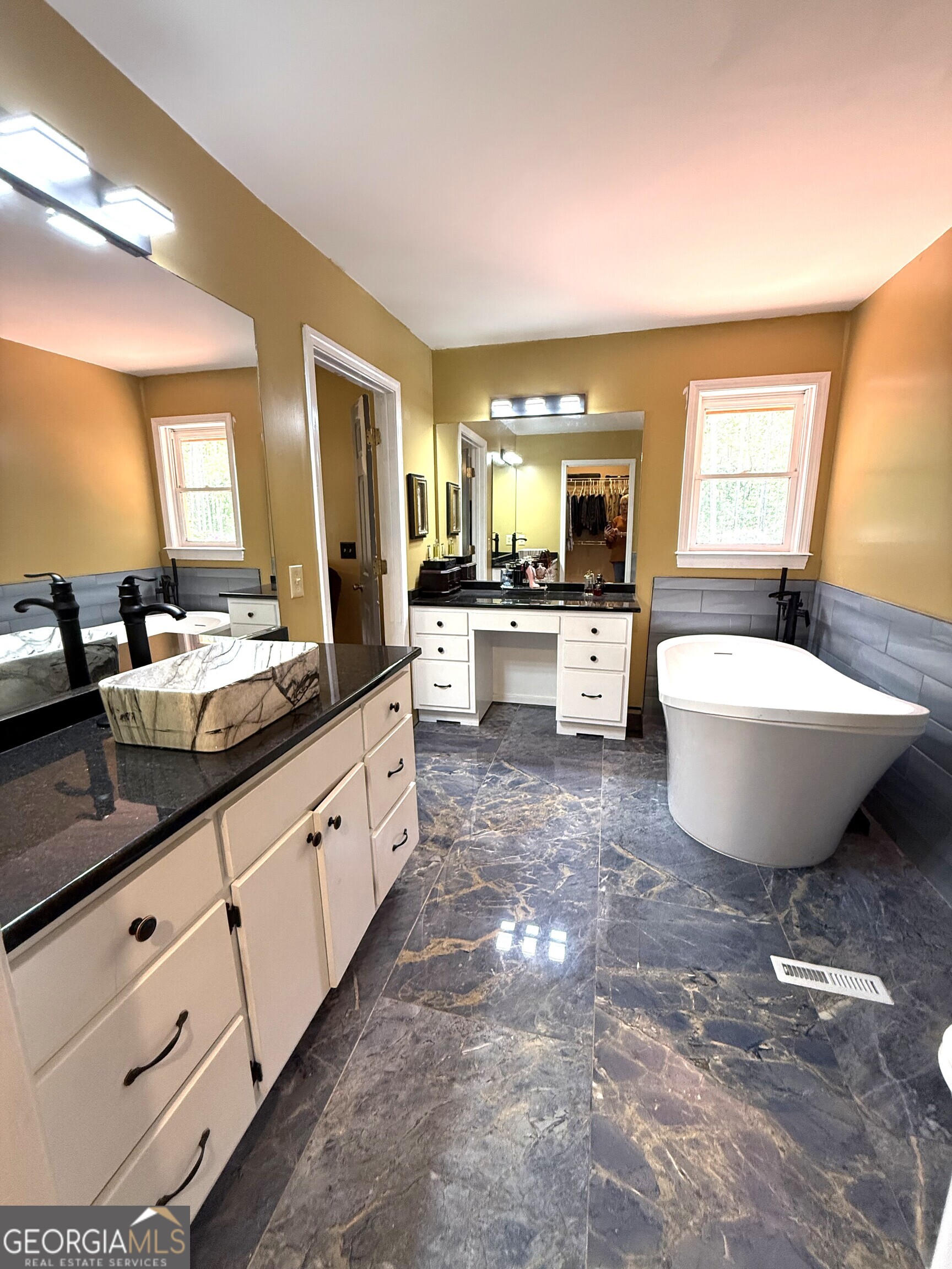 725 Musgrove Road Griffin, GA 30223 - Photo 20 of 52 a large bathroom with double vanity sinks a large mirror and a bathtub