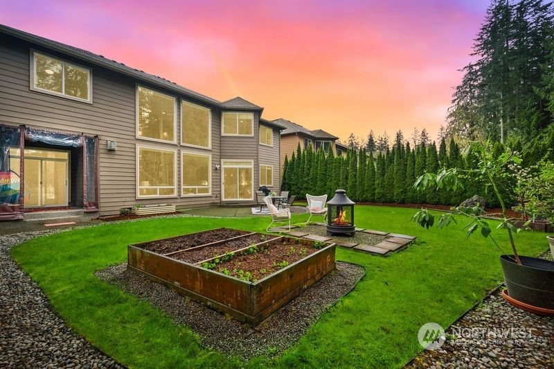 10719 Elliston Way Northeast Redmond, WA 98053 - Photo 32 of 39 a view of a backyard with couches plants and large trees