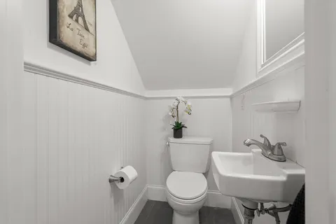 a bathroom with a toilet sink and mirror