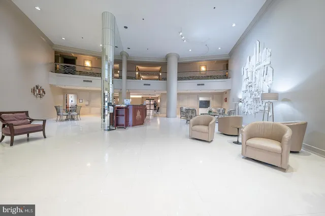 a living room with furniture kitchen view and a chandelier