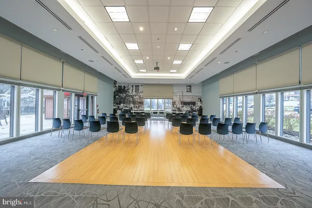 a large hall with dining table and couches with a large window