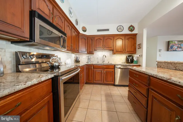 a kitchen with stainless steel appliances granite countertop a stove sink and cabinets