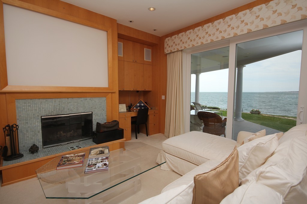 128 Point Road Marion, MA 02738 - Photo 10 of 25 a living room with furniture a fireplace and a floor to ceiling window