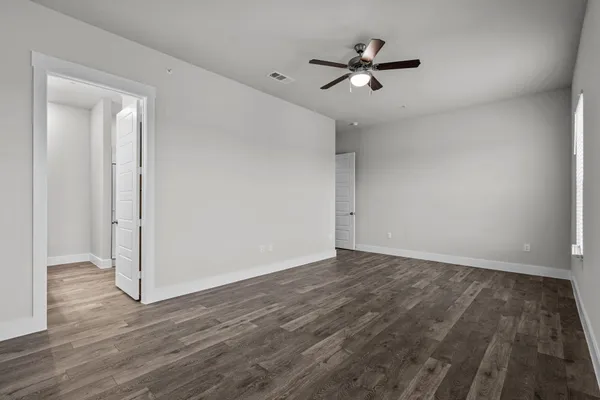 an empty room with wooden floor and windows