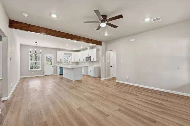 wooden floor in an empty room with a kitchen