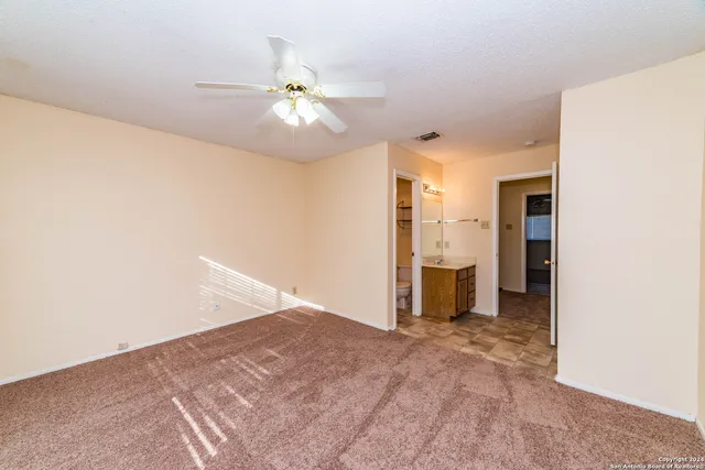 a view of an empty room with closet and chandelier fan