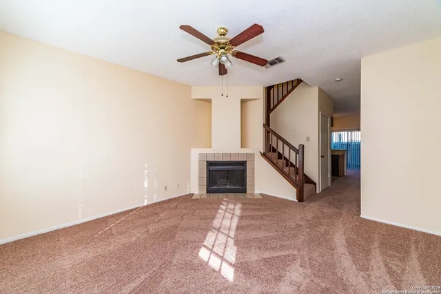 an empty room with ceiling fan and entryway