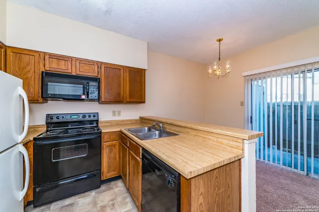 a kitchen with granite countertop a stove and a sink