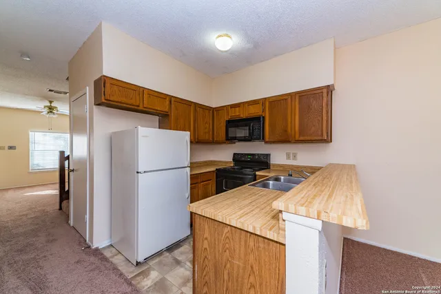 a kitchen with a refrigerator a stove top oven a sink and dishwasher