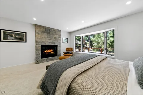 a bed sitting in a spacious bedroom next to a fireplace
