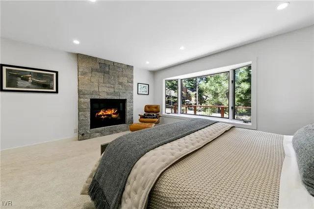 a bed sitting in a spacious bedroom next to a fireplace