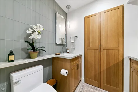 a bathroom with a toilet sink and mirror