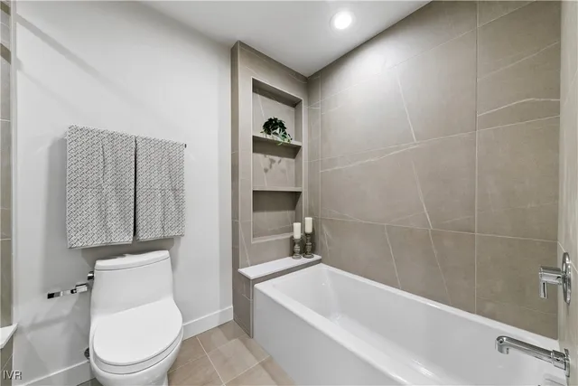 a white toilet sitting next to a bathtub